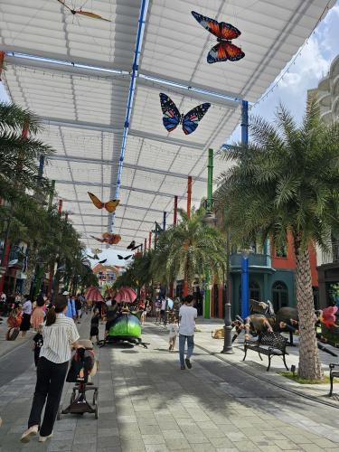 a group of people walking in a mall with butterflies on the ceiling at Ho Tram Beach House in Xuyên Mộc