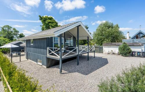 a small blue building with a porch on a gravel yard at Beautiful Home In Strøby With Wifi in Strøby