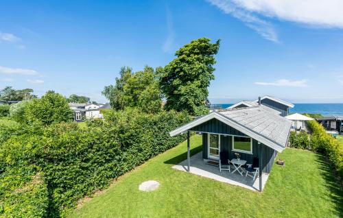 une petite maison sur une pelouse à côté de l'océan dans l'établissement Beautiful Home In Strøby With Wifi, à Strøby