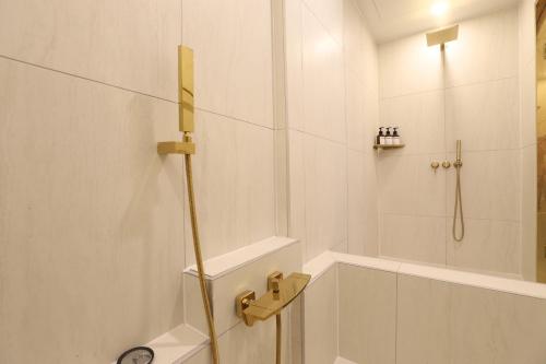 a white bathroom with a shower and a tub at Geoje Hound Hotel & Spa in Geoje 