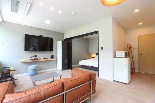 a living room with a couch and a bed at Geoje Hound Hotel & Spa in Geoje 