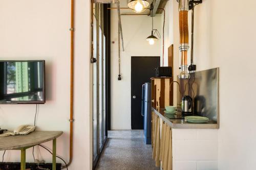 a kitchen with a counter and a tv on a wall at Belakang Kong Heng Ipoh Hotel in Ipoh