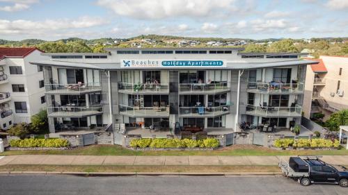 an apartment building with a van parked in front of it at Beaches on Lammermoor Apartments in Yeppoon