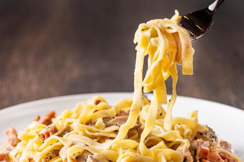 a fork picking up a piece of pasta on a plate at Candeo Hotels Osaka The Tower in Osaka
