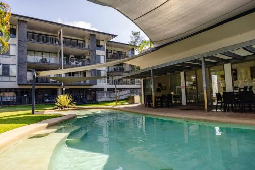 an empty swimming pool in front of a building at Beaches on Lammermoor Apartments in Yeppoon