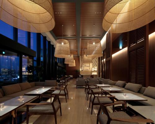 a restaurant with tables and chairs and large windows at Candeo Hotels Osaka The Tower in Osaka