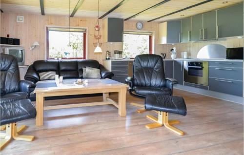 a living room with leather chairs and a table at Holiday Home Nørre Nebel 42 in Lønne Hede
