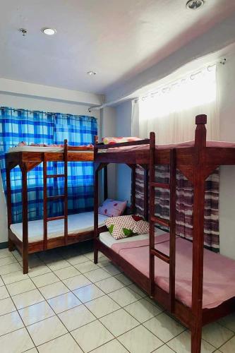 two bunk beds in a room with a window at Istroberi Inn Palawan near Airport in Puerto Princesa City