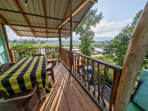 a wooden balcony with a table and chairs on it at Ridge Boundary View in Dambulla