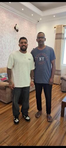 two men standing next to each other in a living room at White House Bungalow Hatton in Hatton