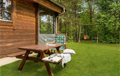 a picnic table and a chair next to a cabin at Two-Bedroom Holiday Home In Herning in Herning