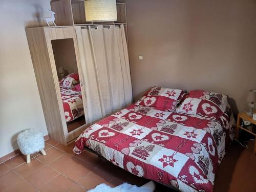 a bedroom with a red bed and a mirror at Maison de montagne FONT ROMEU in Font Romeu Odeillo Via