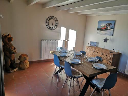 a dining room with a table with chairs and a clock at Maison de montagne FONT ROMEU in Font Romeu Odeillo Via