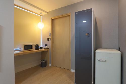 a small room with a refrigerator and a microwave at Geoje Hound Hotel & Spa in Geoje 