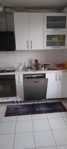 une cuisine avec des armoires blanches et une cuisinière dans l'établissement Privat Zimmer in eine whg rue des abeilles, à Mulhouse