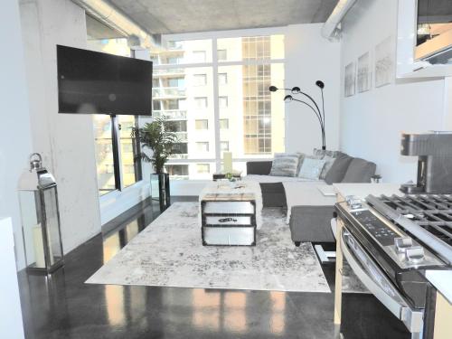 a white living room with a couch and a table at Modern Cozy Nest in Calgary