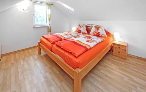 a bedroom with a large bed with an orange comforter at Ferienhaus Jabel Ot Loppin in Loppin