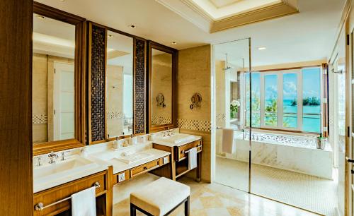 a bathroom with two sinks and a shower at The Danna Langkawi - A Member of Small Luxury Hotels of the World in Pantai Kok