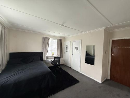 une chambre avec un lit et une chaise dedans dans l'établissement Pet friendly house with hot tub, à Lower Hutt