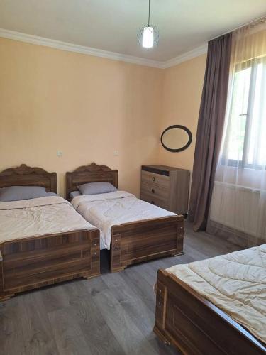 une chambre avec deux lits, un miroir et une fenêtre dans l'établissement Natos Cottage, à Sadgeri