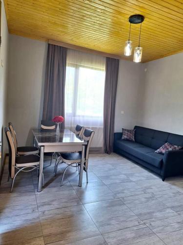 un salon avec une table et un canapé bleu dans l'établissement Natos Cottage, à Sadgeri