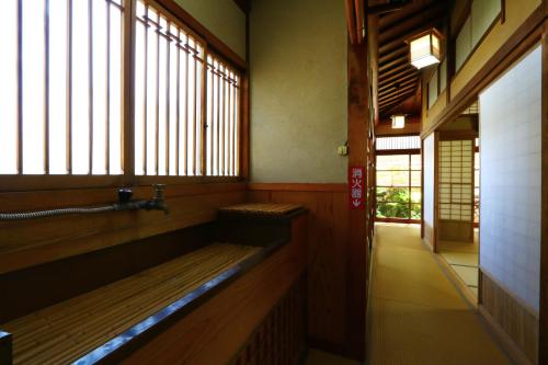 a hallway with a bench in a room with windows at 割烹旅館小川荘 in Ōmiya
