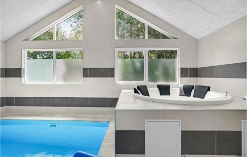 a room with a swimming pool and a tub at Beautiful Home In Væggerløse With Sauna in Marielyst