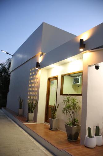 a house with potted plants in front of it at บ้านศรีสุธรรม 2 Baansrisuthum 2 in Surat Thani