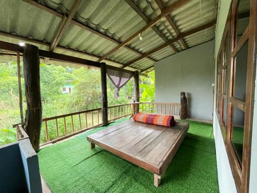 a room with a wooden bench on a balcony at Chiang Dao Hostel in Chiang Dao