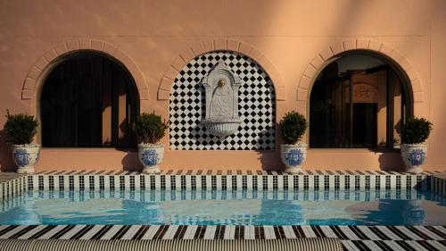 a swimming pool with three potted plants in a building at The Trade Boutique Hotel in Cape Town