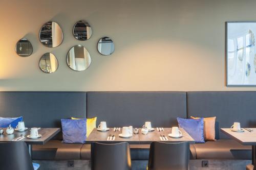 a dining room with wooden tables and chairs and mirrors at Candlewood Suites Augsburg in Augsburg