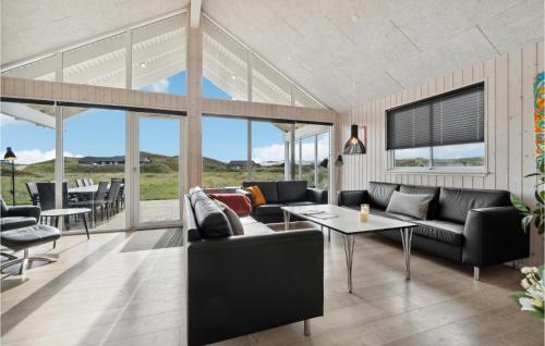 a living room with couches and a table at Awesome Home In Hvide Sande With Sauna in Havrvig