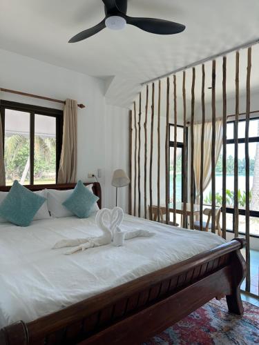 a bedroom with a bed with a ceiling fan at Chic house on the beach in Mae Haad