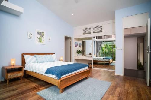 a bedroom with a bed and a table and a mirror at Modern Tranquillity Pool Villa, Layan in Laguna Phuket