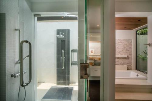 a bathroom with a shower and a bath tub at Modern Tranquillity Pool Villa, Layan in Laguna Phuket