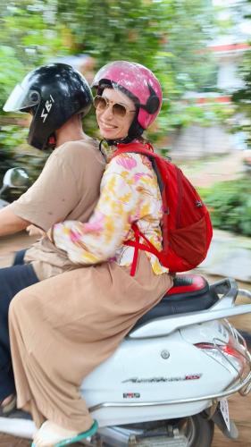 a woman riding a scooter with a person wearing a helmet at CLIFF HEAVEN in Varkala