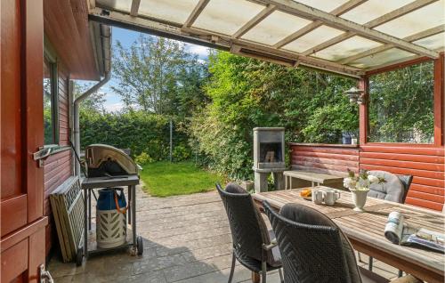 StruerにあるBeautiful Home In Struer With Kitchenのテーブルと椅子とグリルのあるパティオ