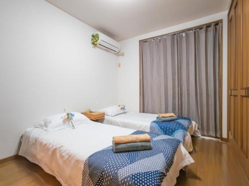 a bedroom with two beds and a window at Happy House 西小岩 京成小岩駅徒歩5分 in Tokyo