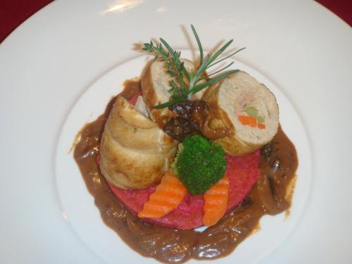 a plate of food with meat and vegetables and gravy at Glorious Hotel in Kompong Thom