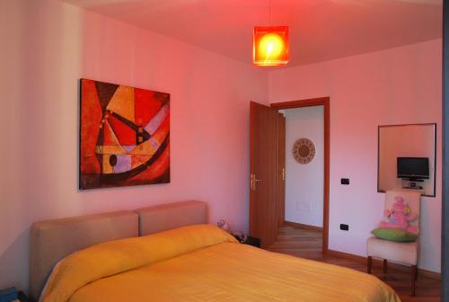 1 dormitorio con 1 cama y una pintura en la pared en Roccesarde Apartment, en Alghero