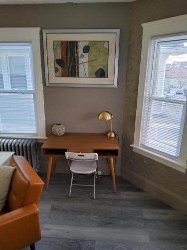 a desk in a room with a chair and two windows at Darma Apartments in Providence