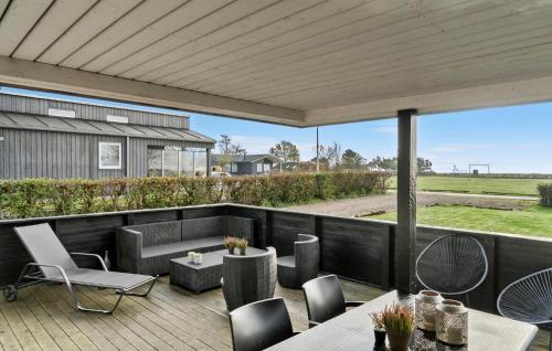 a patio with a table and chairs on a deck at Holiday Home Hejsager Strandby Haderslev Iv in Kelstrup Strand