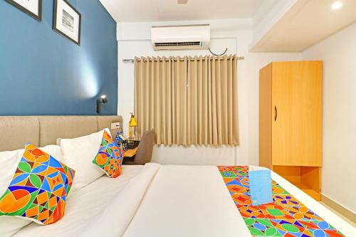 a bedroom with a bed with colorful pillows at FabHotel Azure Sky - Nr Ruby Hospital in Kolkata