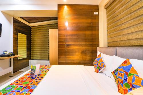 a bedroom with a bed with a wooden wall at FabHotel Azure Sky - Nr Ruby Hospital in Kolkata