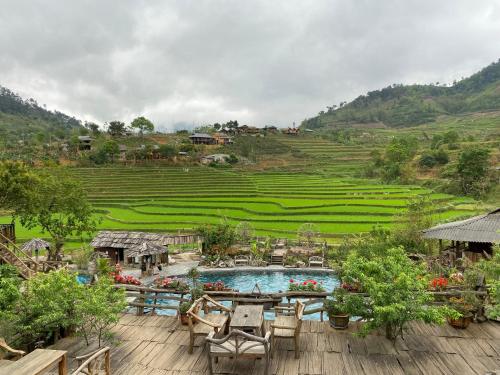 a resort with a pool and a table and chairs at Truong Nhan Tram Tau Homestay in Cham Ta Lao