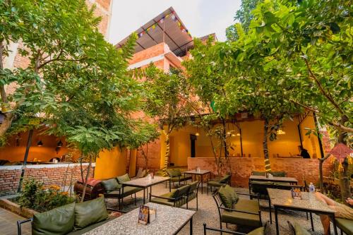 an outdoor patio with tables and chairs and trees at Kwabahal Garden Hostel in Kathmandu