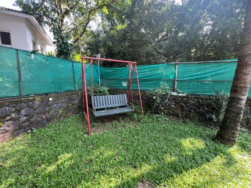 a swing in a yard next to a fence at Beach Side Home Stay - Kihim in Kīhīm