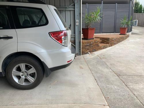 a white car parked in front of a garage at Williams River Retreat in Dungog