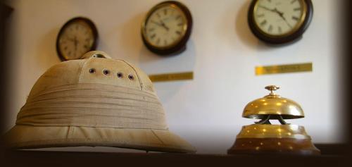 a bell and three clocks on a wall at The Royal Hotel in Riebeek-Kasteel