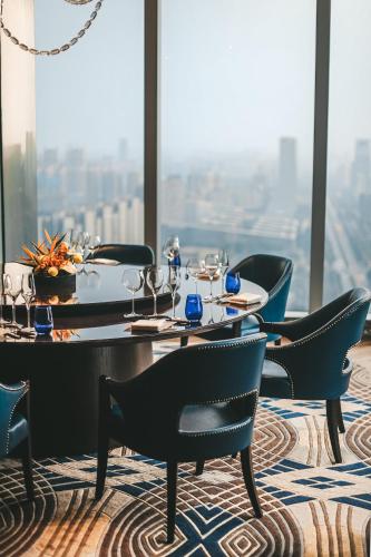 a table and chairs in a restaurant with a view at Fairmont Chengdu in Chengdu